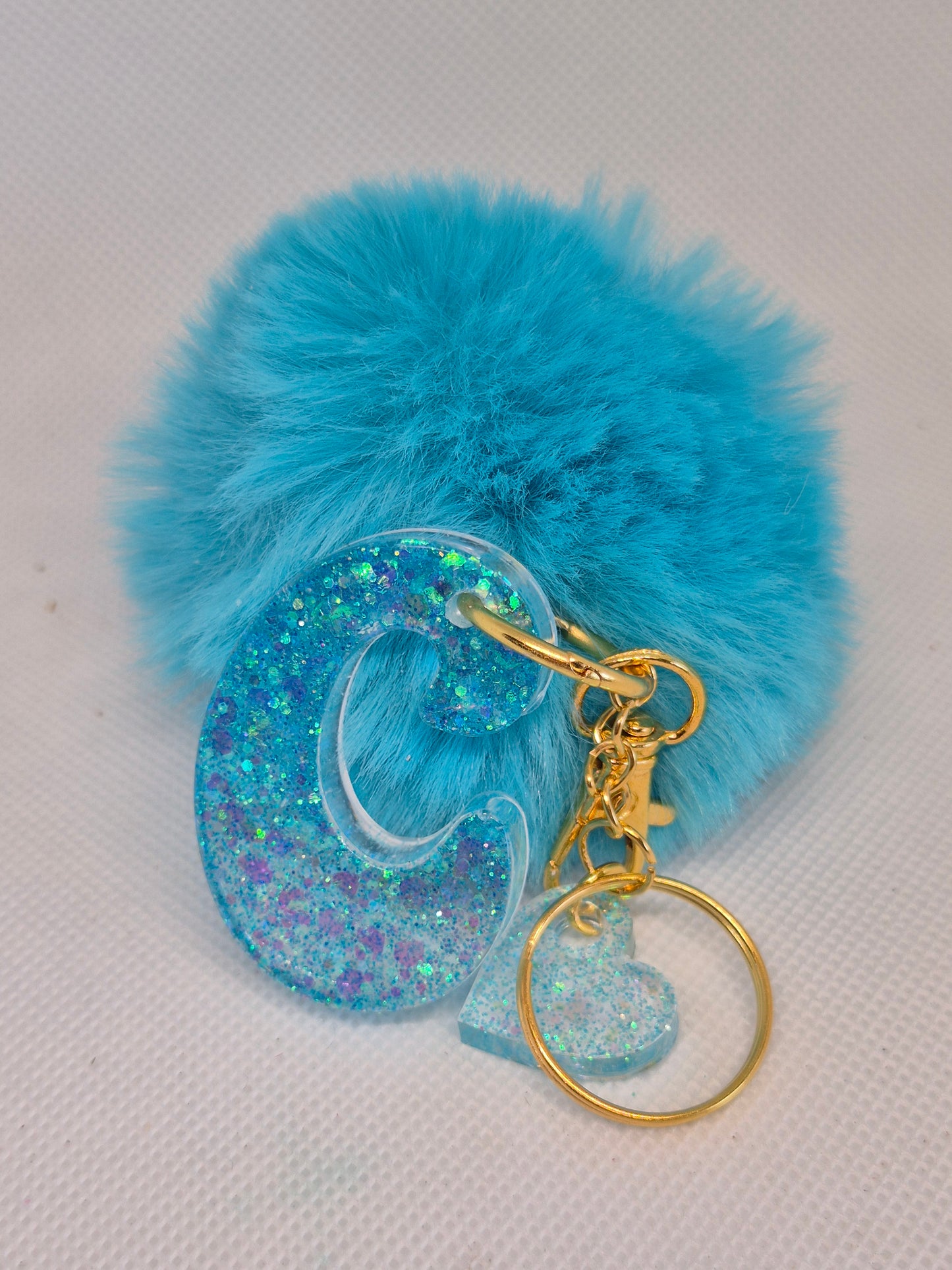 Llavero letra C en resina epoxi azul turquesa con pompón