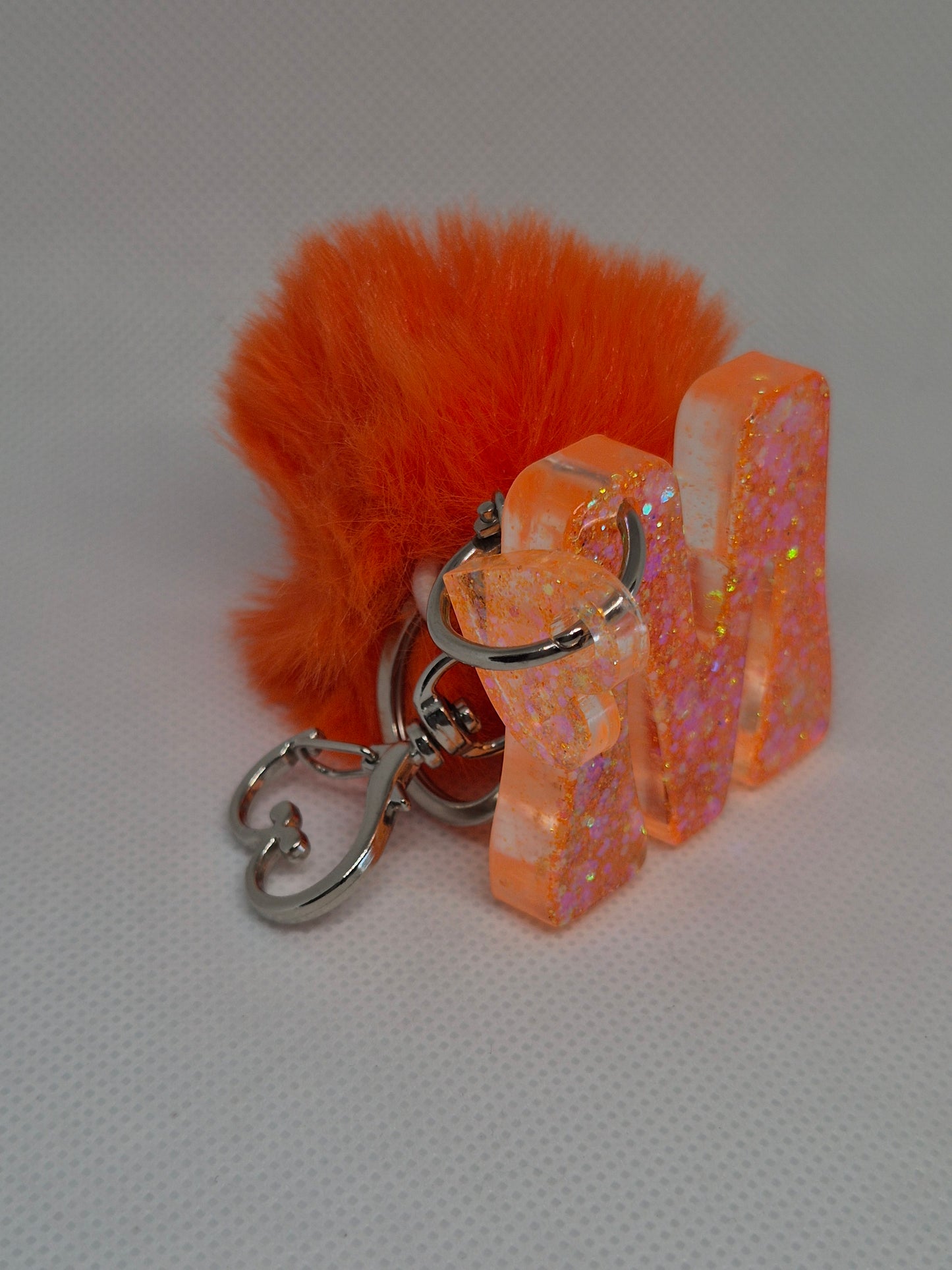 Llavero letra M naranja con pompón