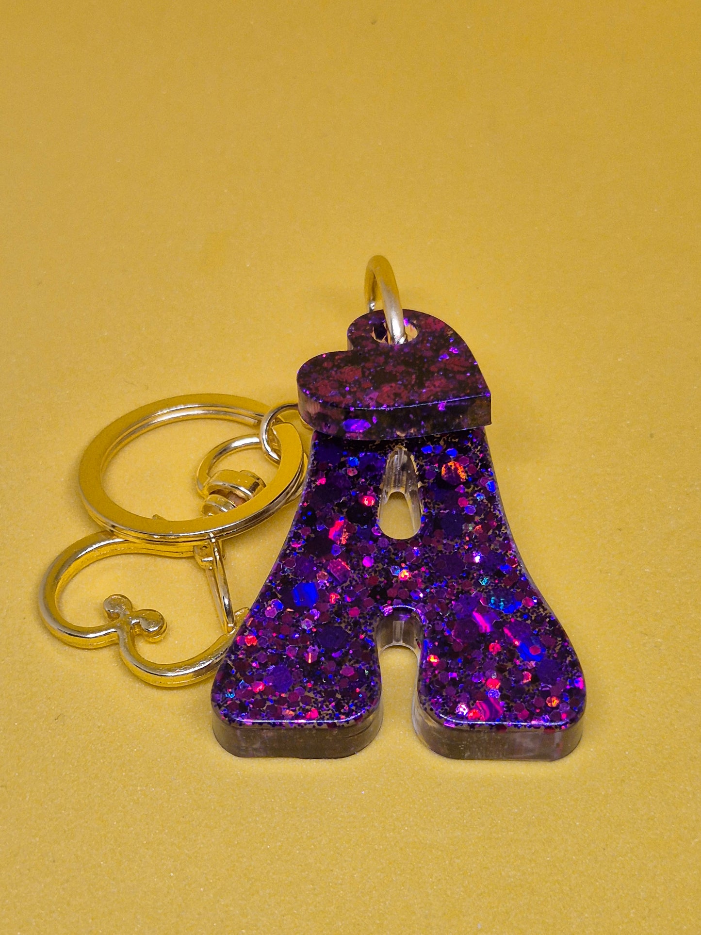 Llavero letra A morado con brillo holográfico y corazón decorativa
