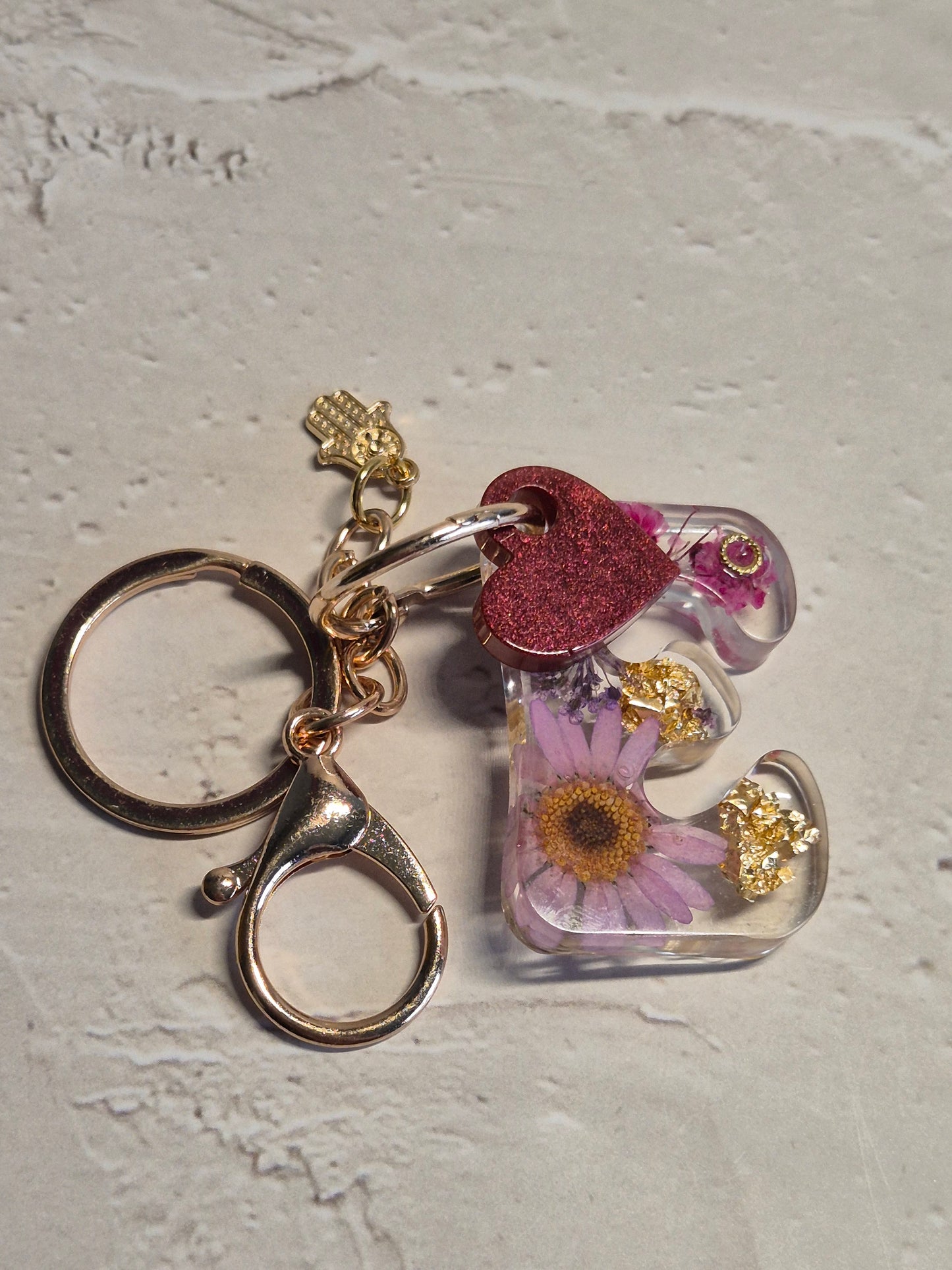 Llavero letra E de resina epoxi transparente con flores secas, pan de oro y corazón rosa glitter