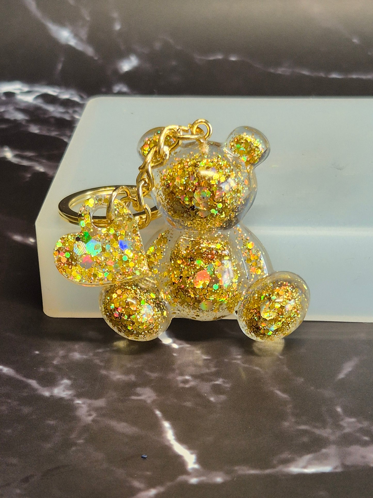 Llavero osito de resina epoxi dorado con glitter y colgante de corazón