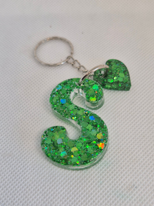 Llavero letra S en resina epoxi verde con glitter y charm de corazón