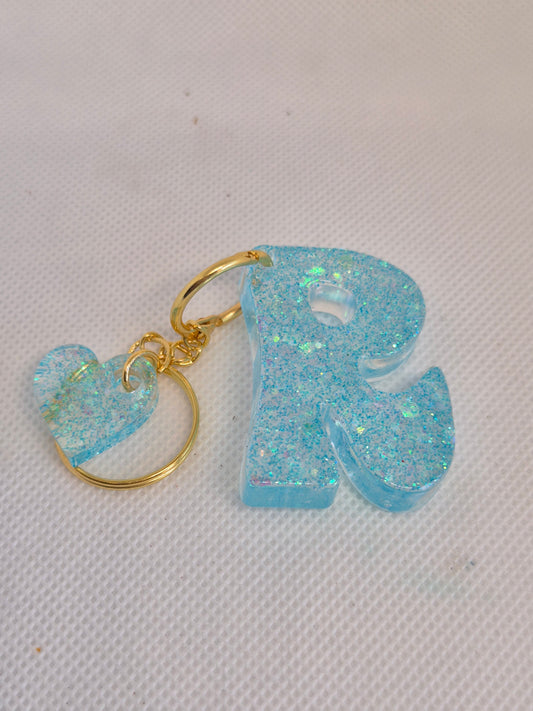 Llavero letra R en resina epoxi azul claro con glitter y charm de corazón