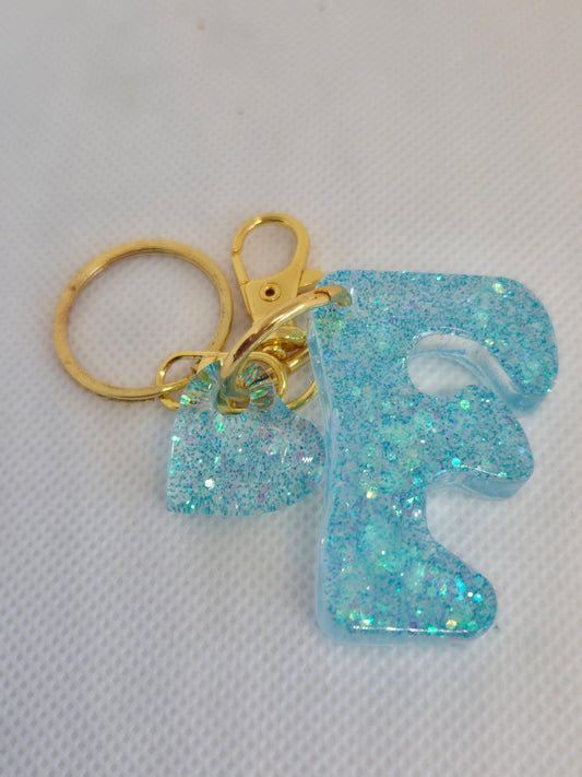 Llavero letra F en resina epoxi azul claro con glitter y charm de corazón