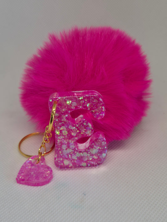 Llavero letra E en resina epoxi rosa con glitter y pompón