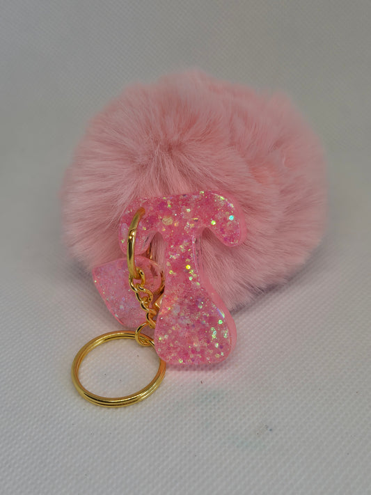 Llavero letra T en resina epoxi rosa con glitter y pompón
