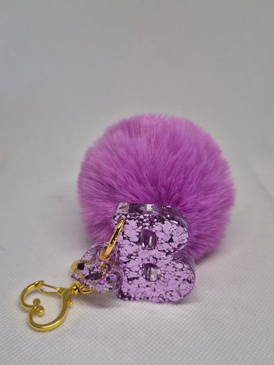 Llavero letra B en resina epoxi lila con glitter y pompón