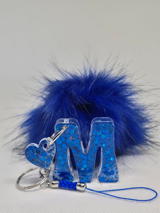 Llavero letra M en resina epoxi azul con pompón