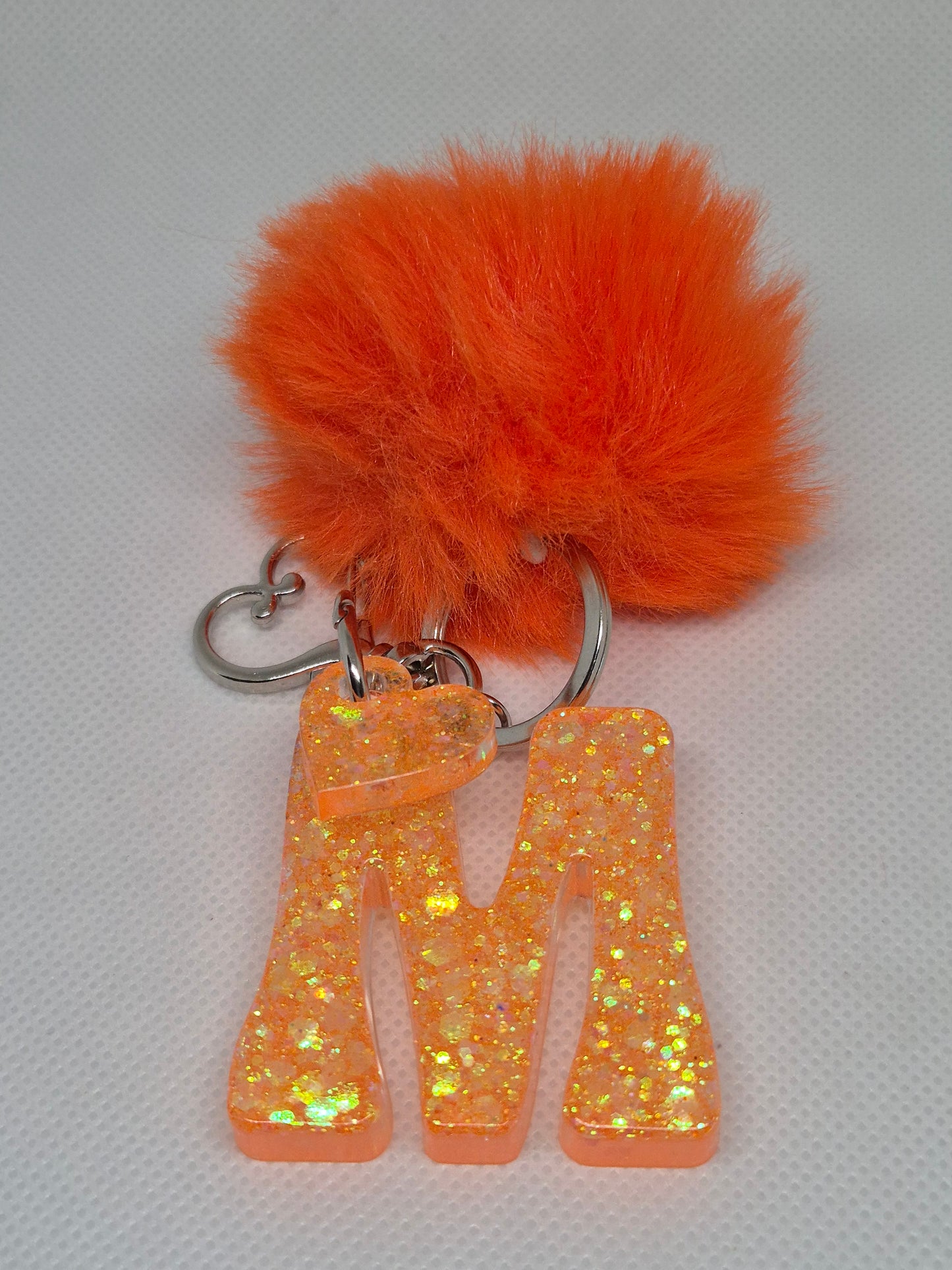 Llavero letra M naranja con pompón