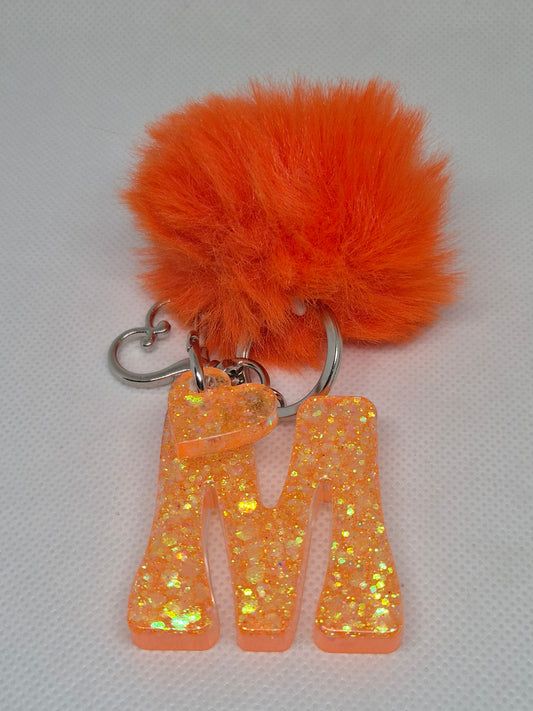 Llavero letra M naranja con pompón