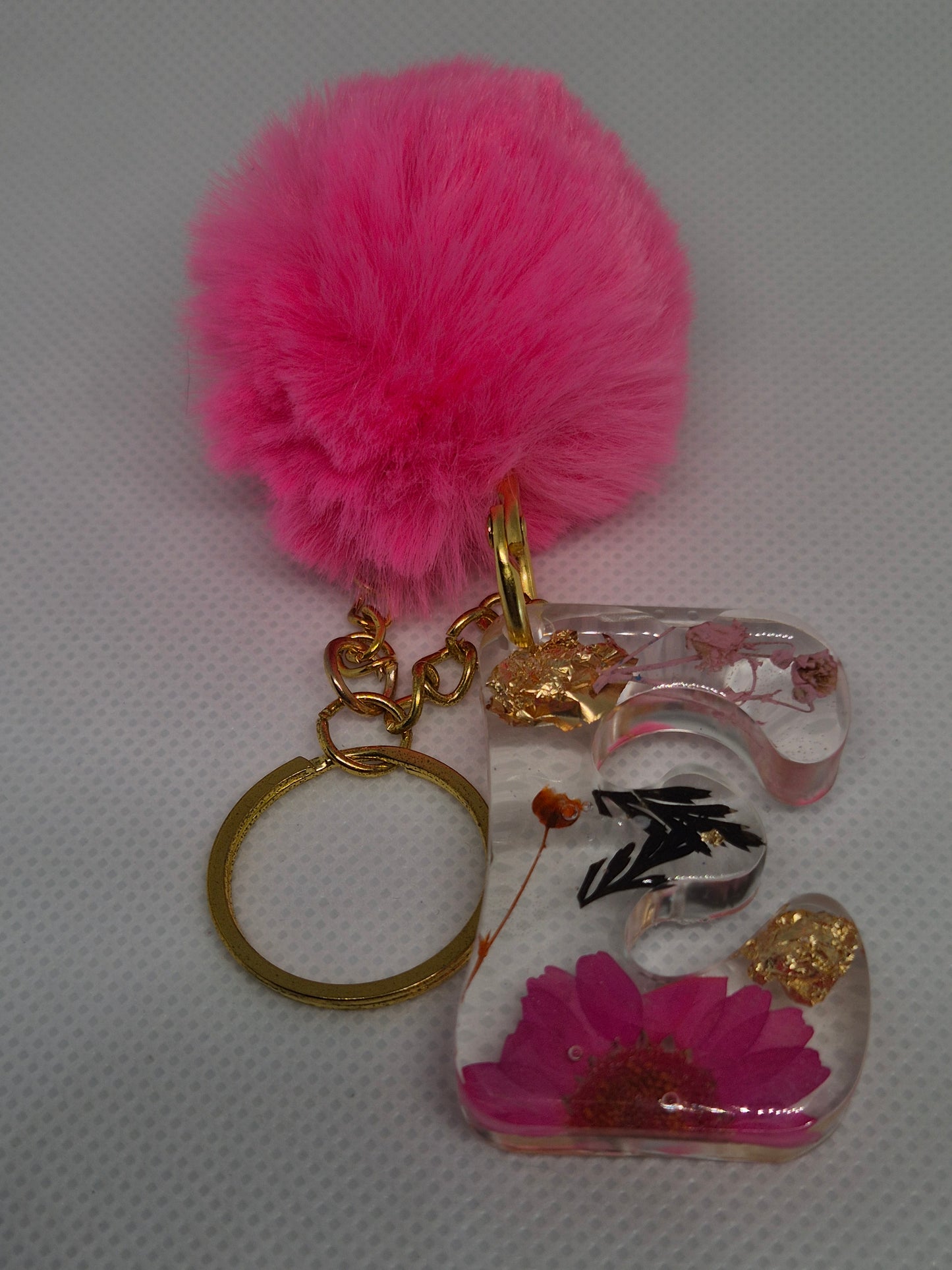 Llavero letra C con flor rosa y pompón fucsia
