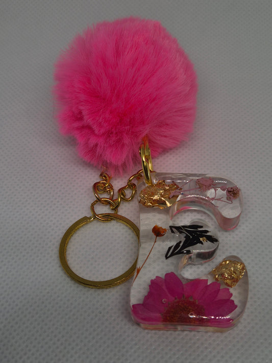 Llavero letra C con flor rosa y pompón fucsia