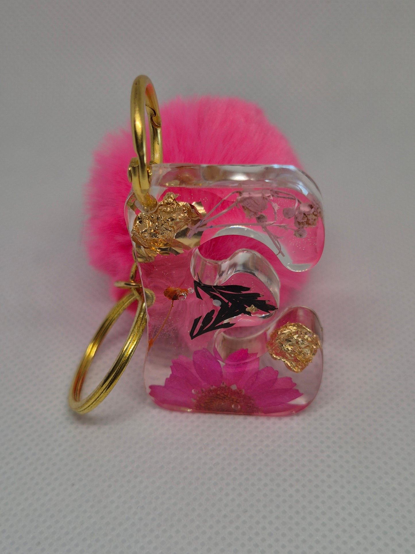 Llavero letra C con flor rosa y pompón fucsia