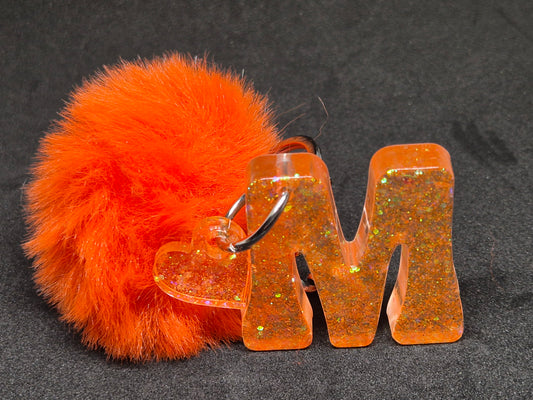 Llavero letra M naranja con brillo, corazón y pompón