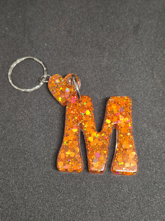 Llavero letra M naranja con brillo y corazón