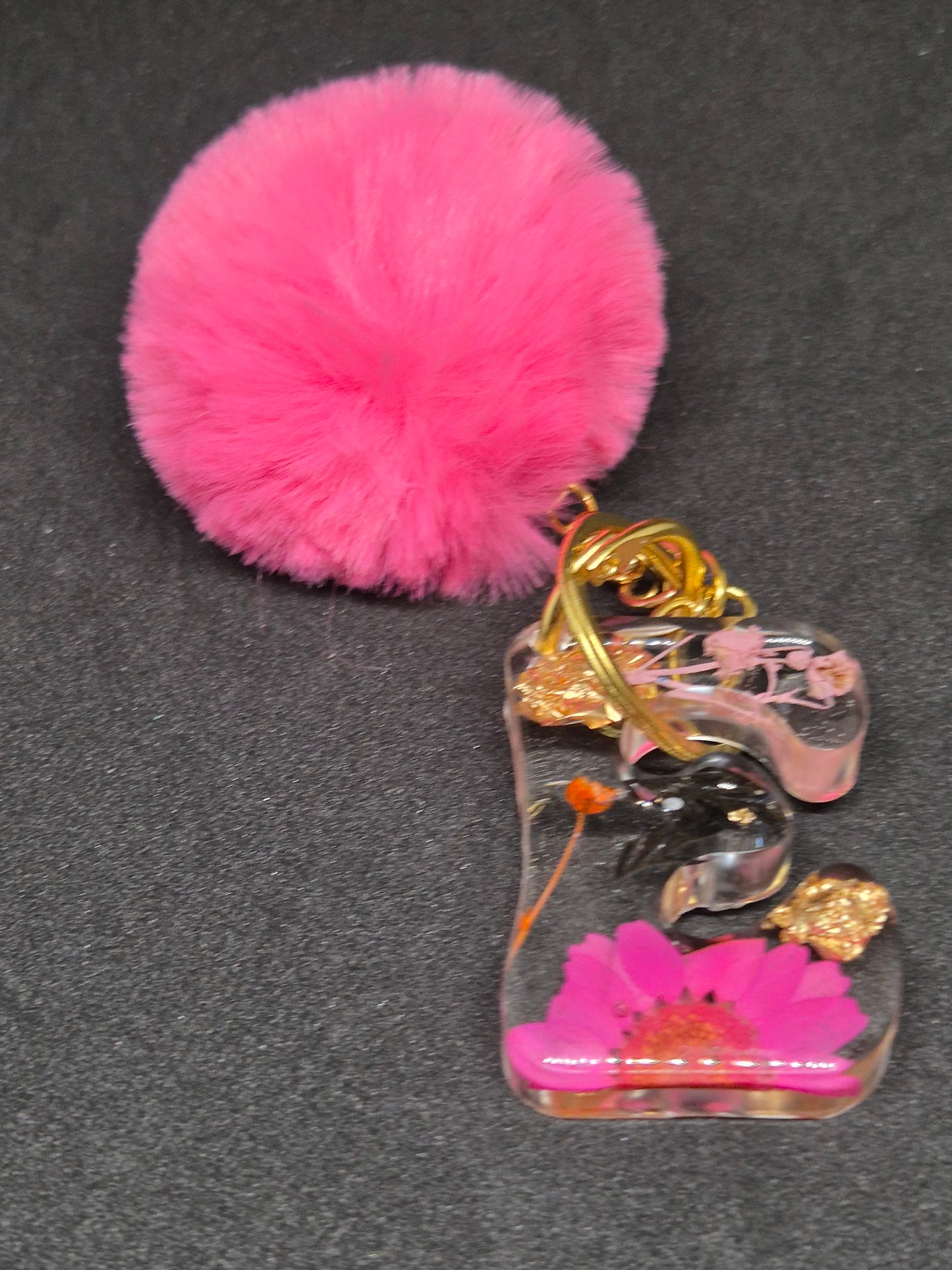 Llavero letra E transparente con flor fucsia y pompón rosa