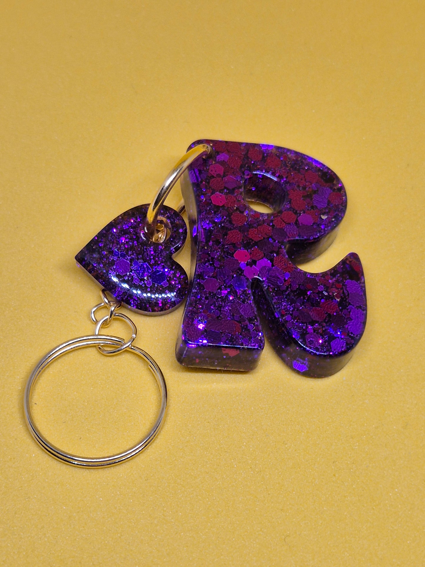 Llavero letra R morado con brillo holográfico y hoja decorativa