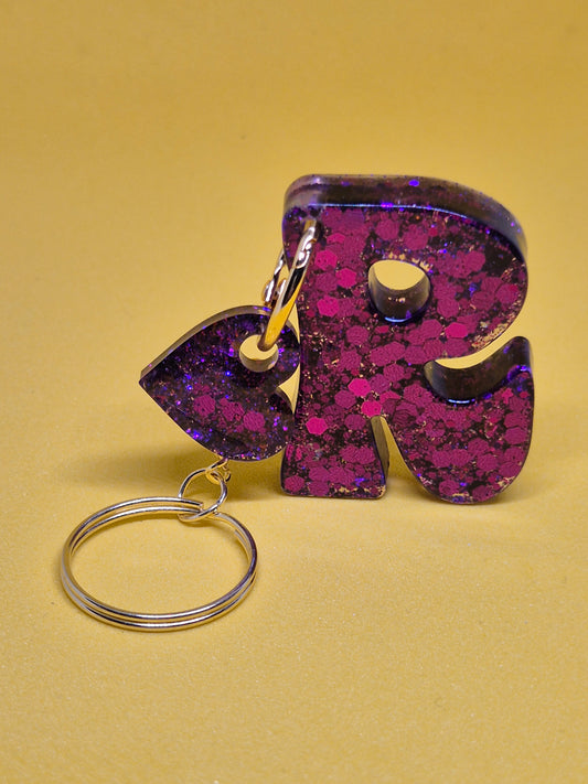 Llavero letra R morado con brillo holográfico y hoja decorativa