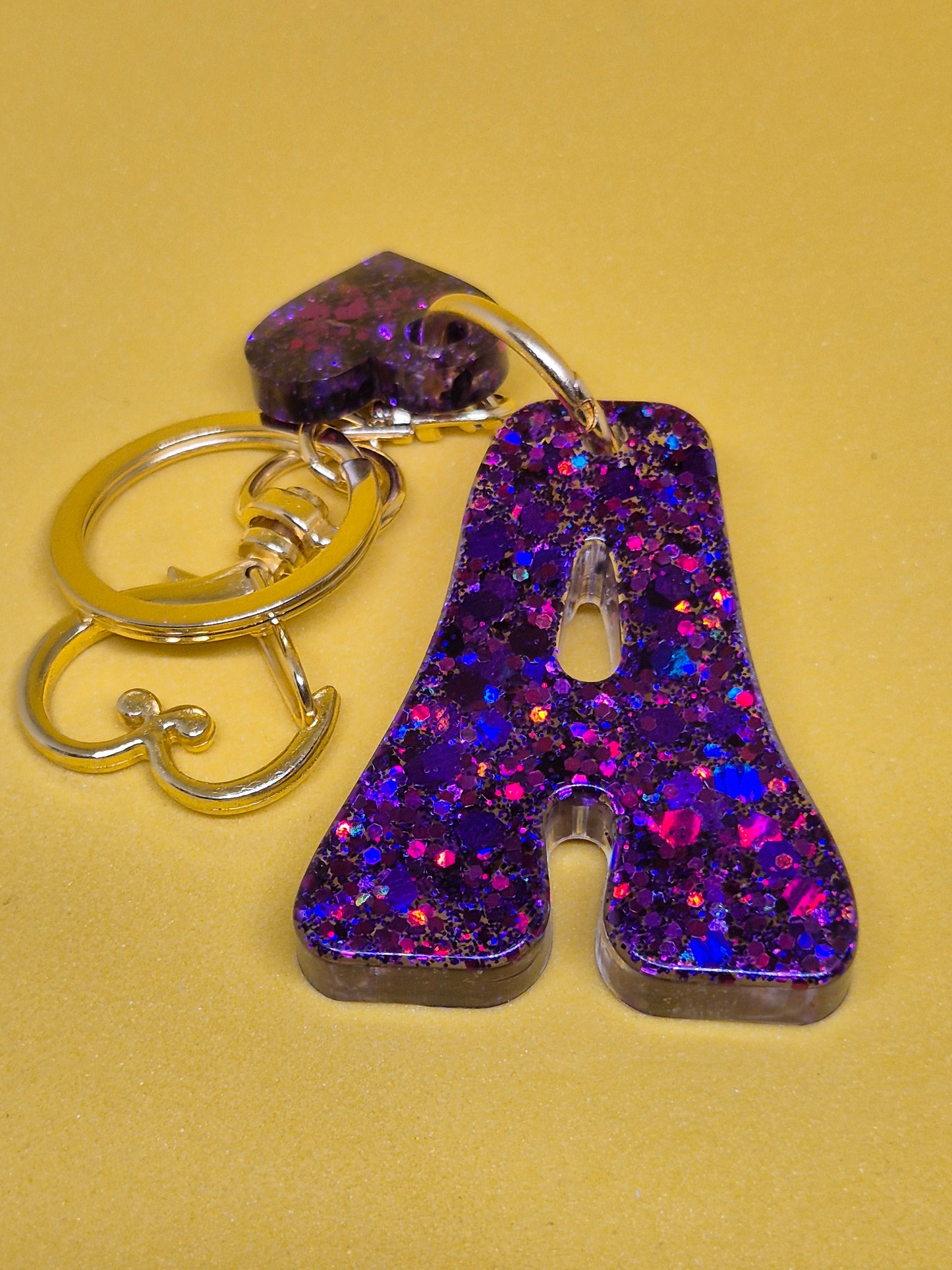 Llavero letra A morado con brillo holográfico y corazón decorativa