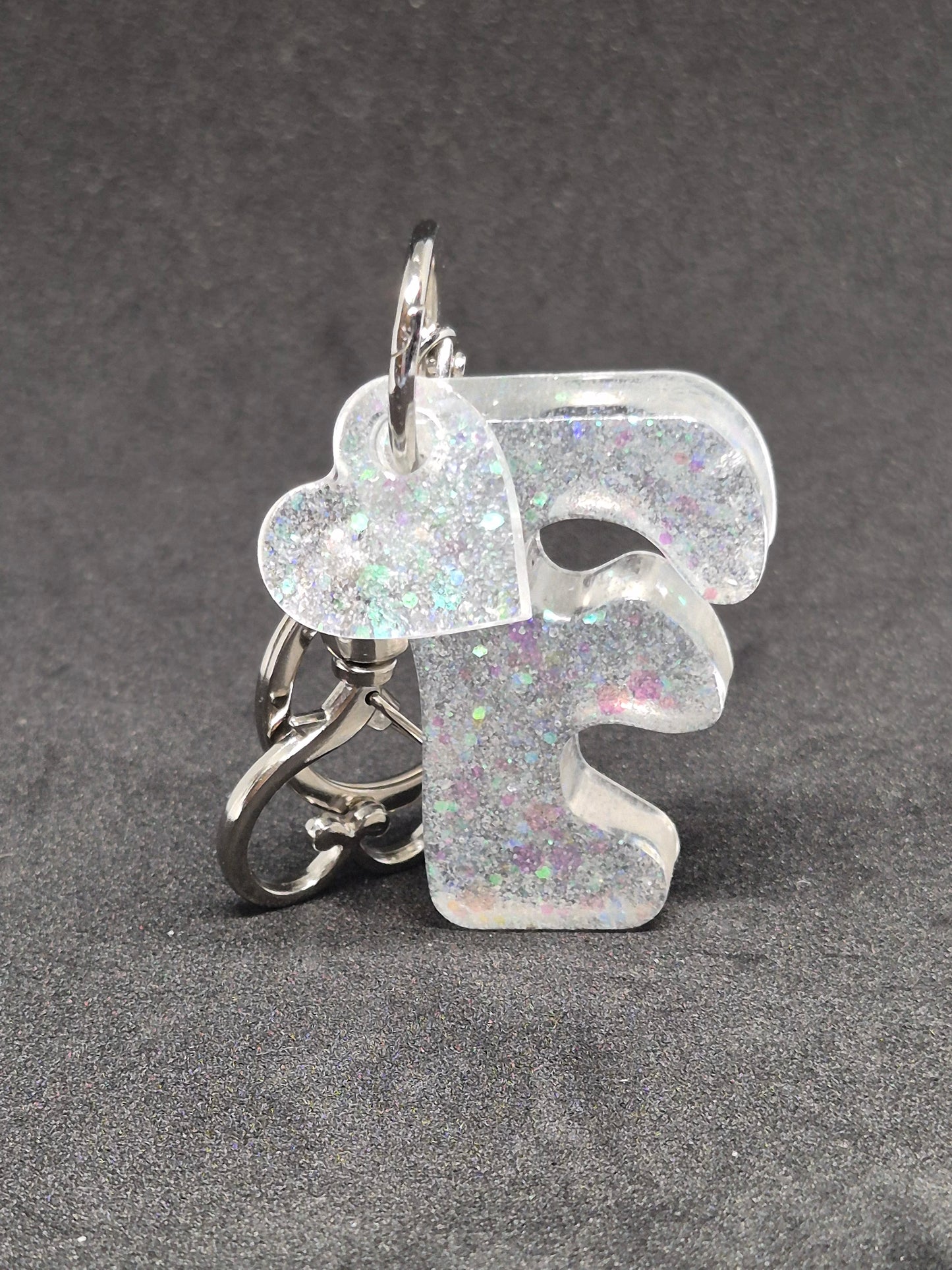 Llavero letra F blanco irisado con brillo holográfico y corazón decorativo
