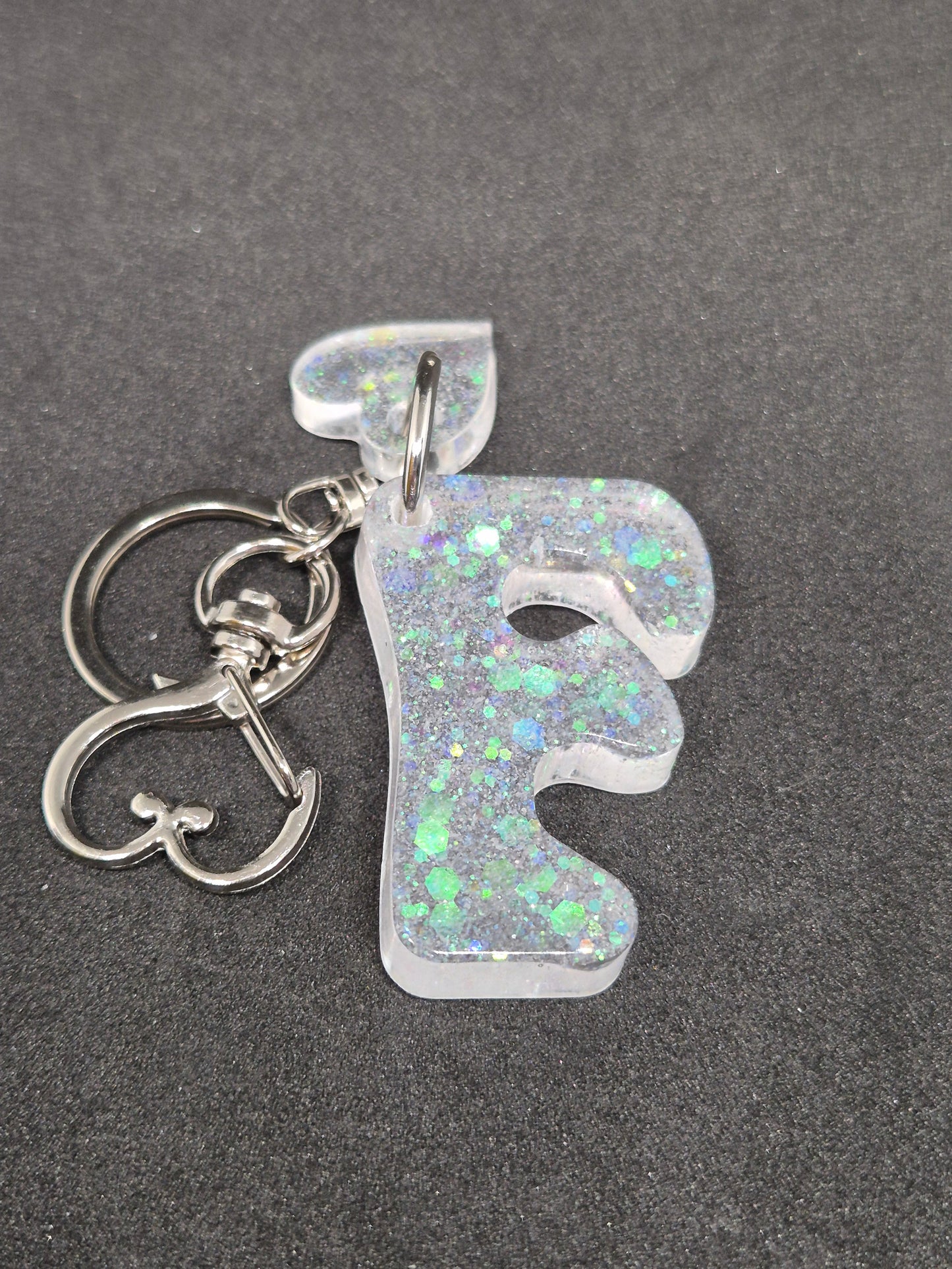 Llavero letra F blanco irisado con brillo holográfico y corazón decorativo