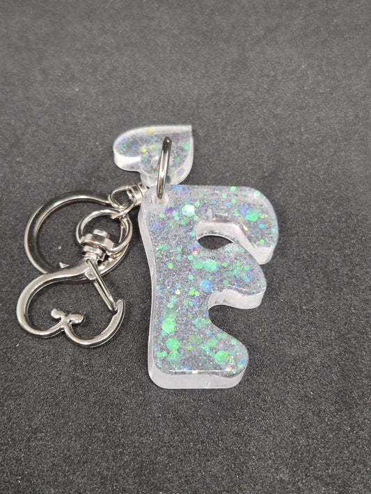 Llavero letra F blanco irisado con brillo holográfico y corazón decorativo