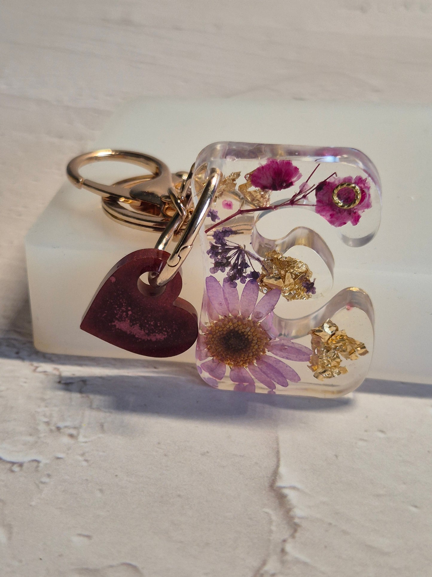 Llavero letra E de resina epoxi transparente con flores secas, pan de oro y corazón rosa glitter