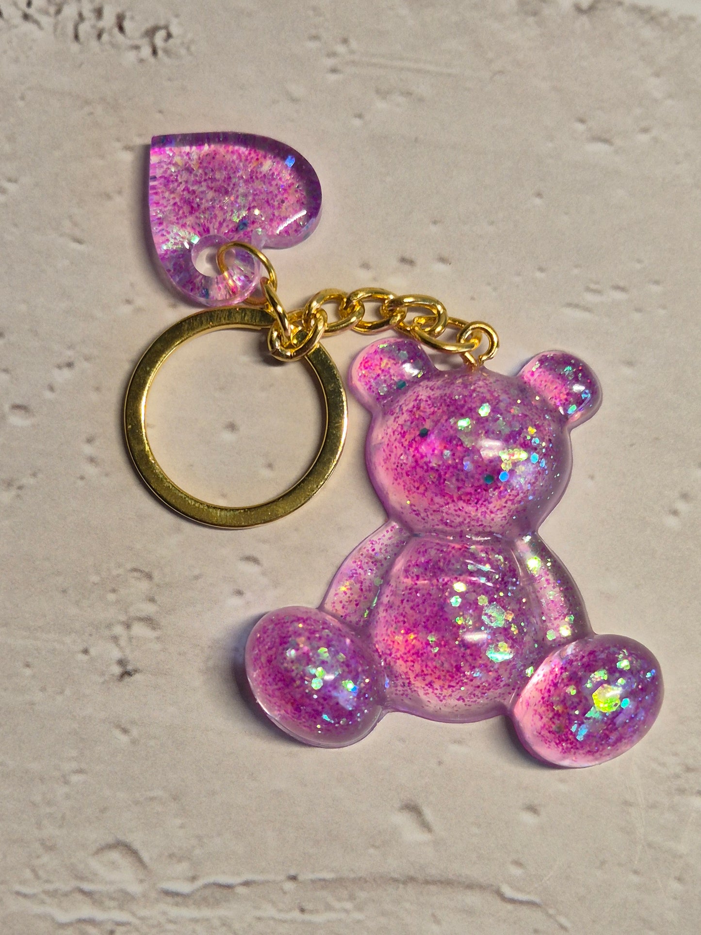 Llavero osito de resina epoxi rosa lila transparente con brillo holográfico y corazón
