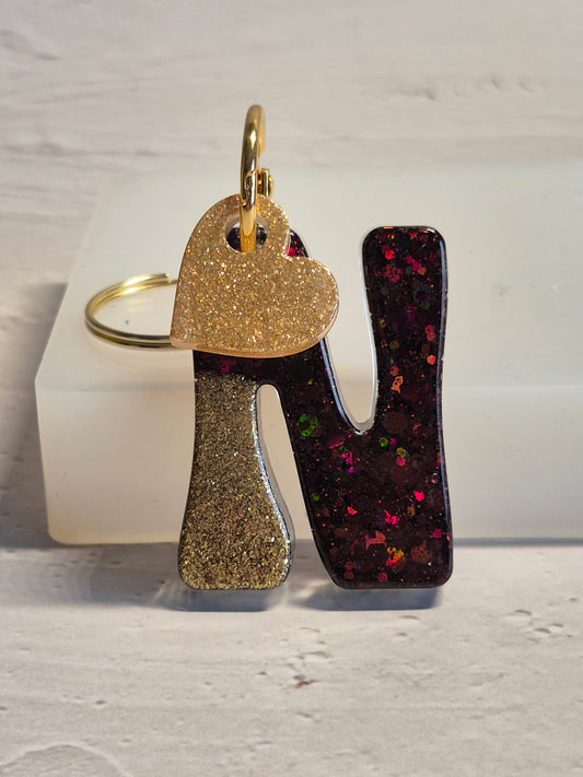 Llavero letra N de resina epoxi negro y dorado con brillo holográfico y corazón