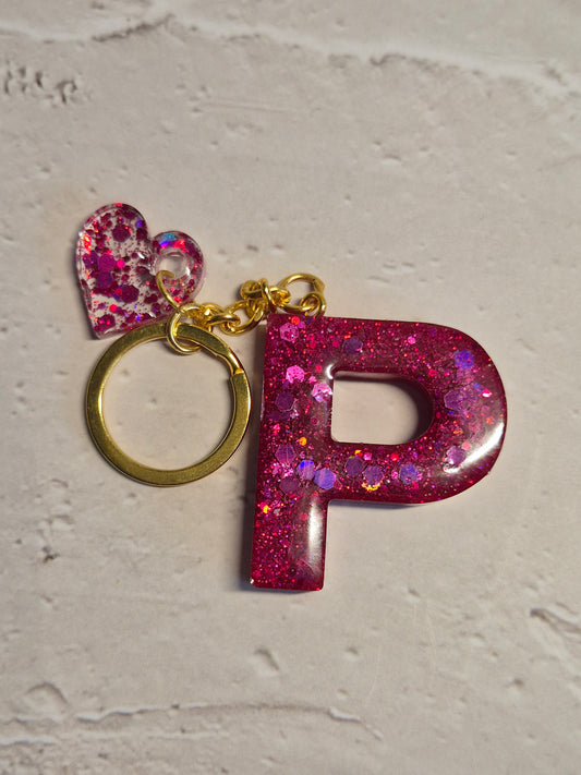 Llavero letra P de resina epoxi fucsia con brillo holográfico y corazón
