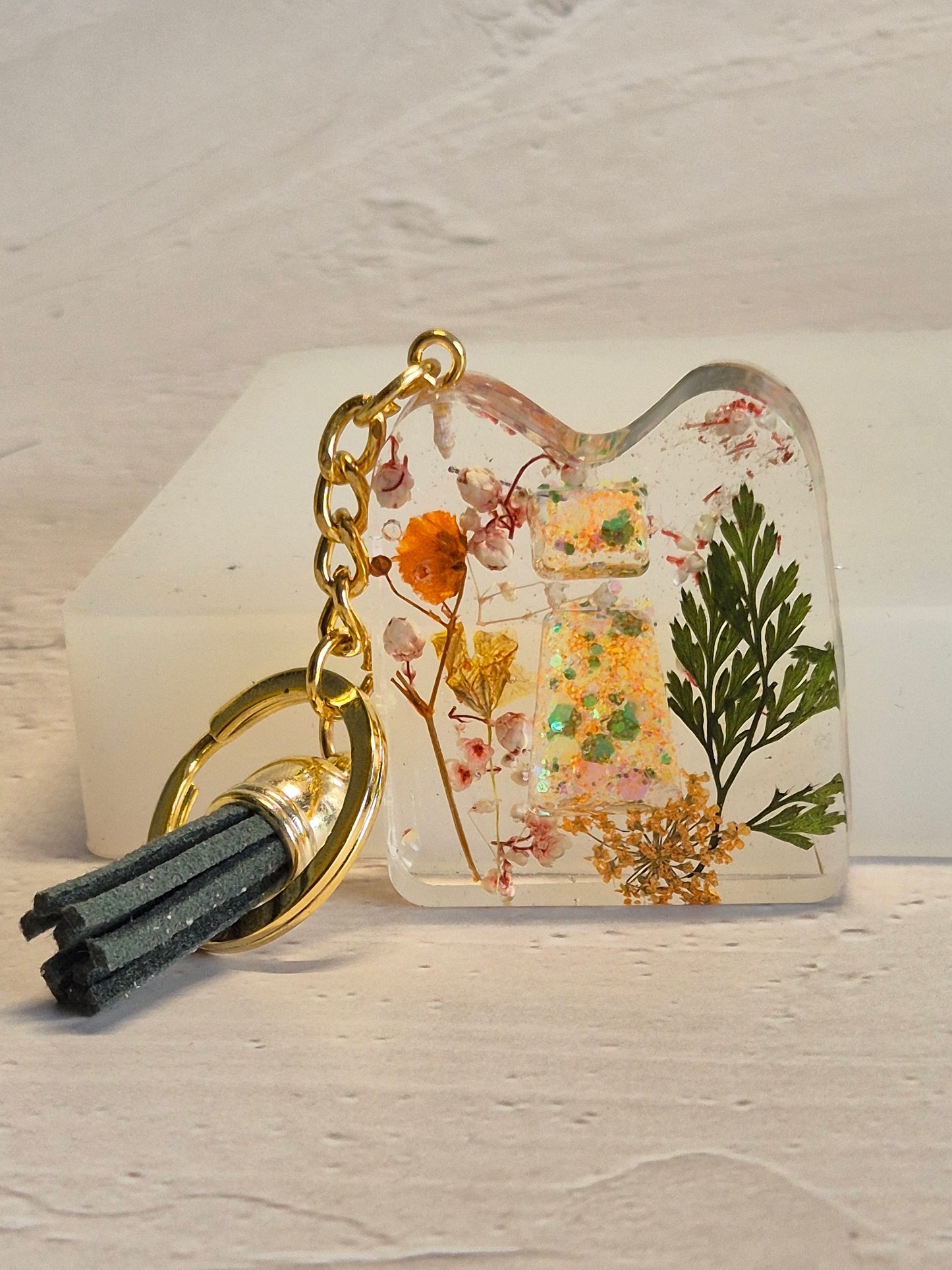 Llavero letra I de resina epoxi transparente con flores secas, hoja verde y borla verde oscuro