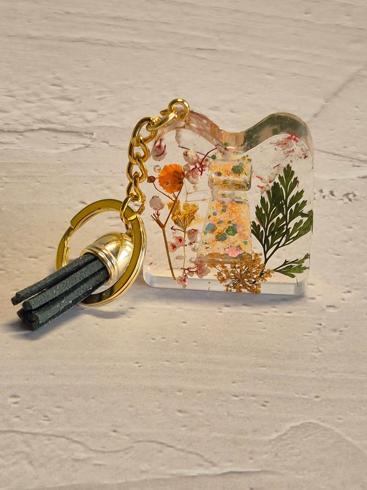 Llavero letra I de resina epoxi transparente con flores secas, hoja verde y borla verde oscuro