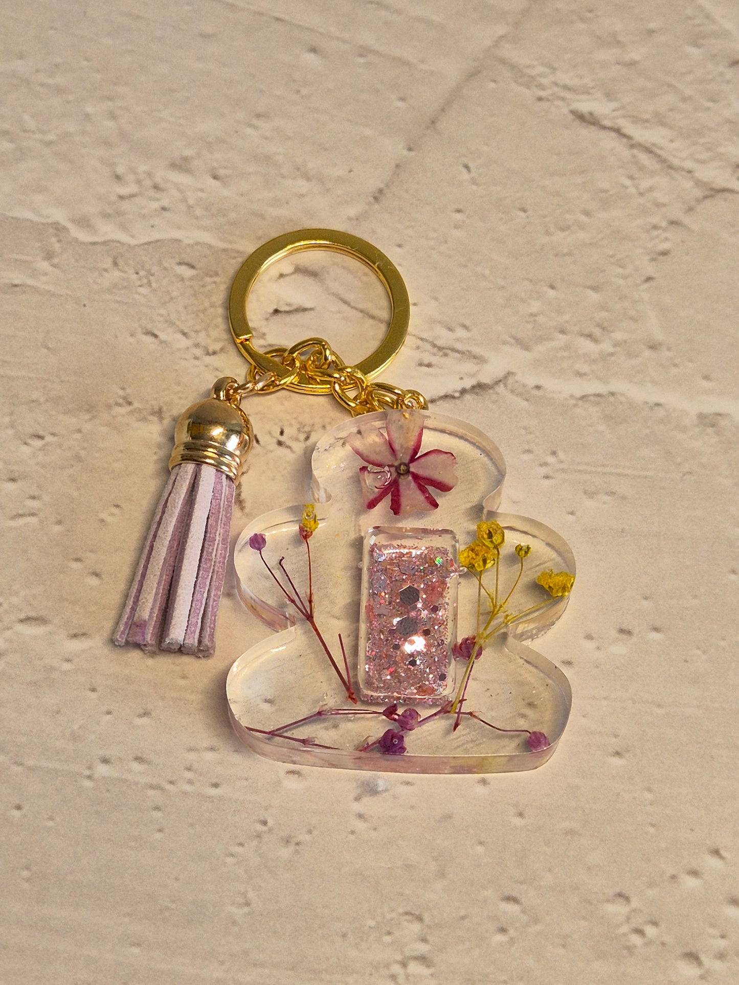 Llavero letra I floral de resina epoxi transparente con flores secas y borla lila