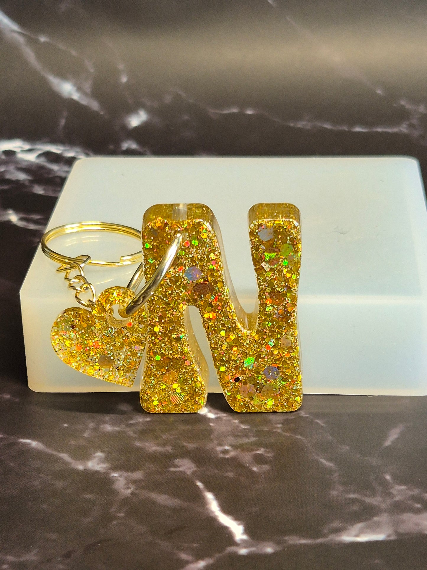 Llavero letra N de resina epoxi dorada con glitter y colgante de corazón