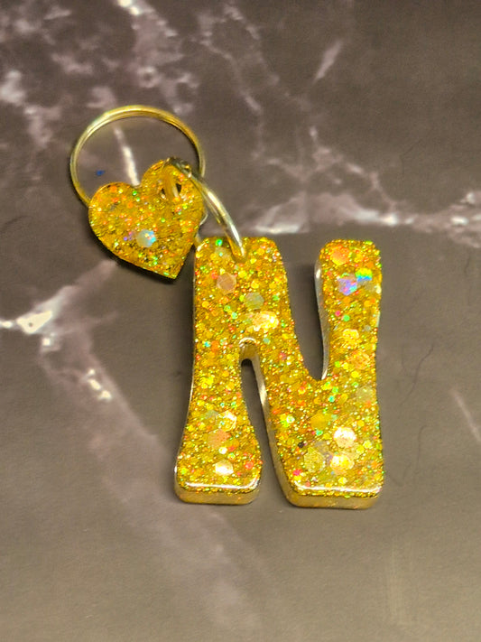 Llavero letra N de resina epoxi dorada con glitter y colgante de corazón