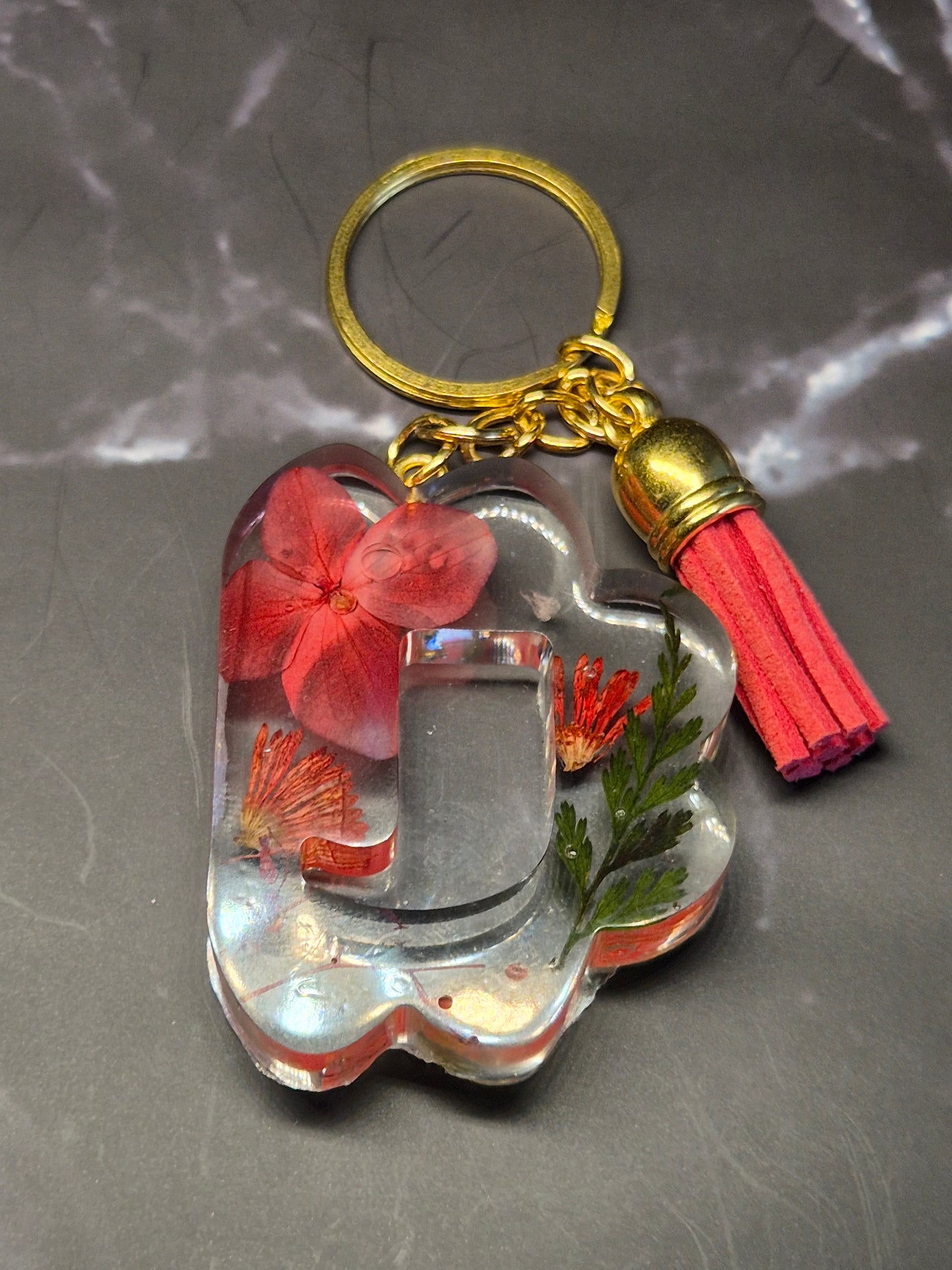 Llavero letra J de resina epoxi transparente con flores rojas y borla roja