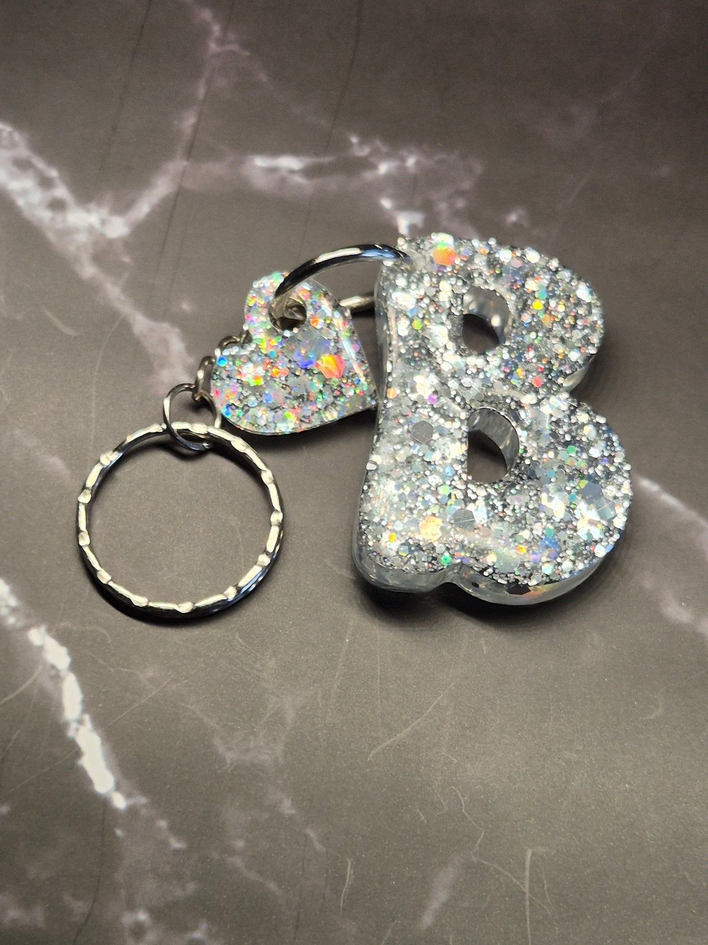 Llavero letra B de resina epoxi plateada con glitter y colgante de corazón