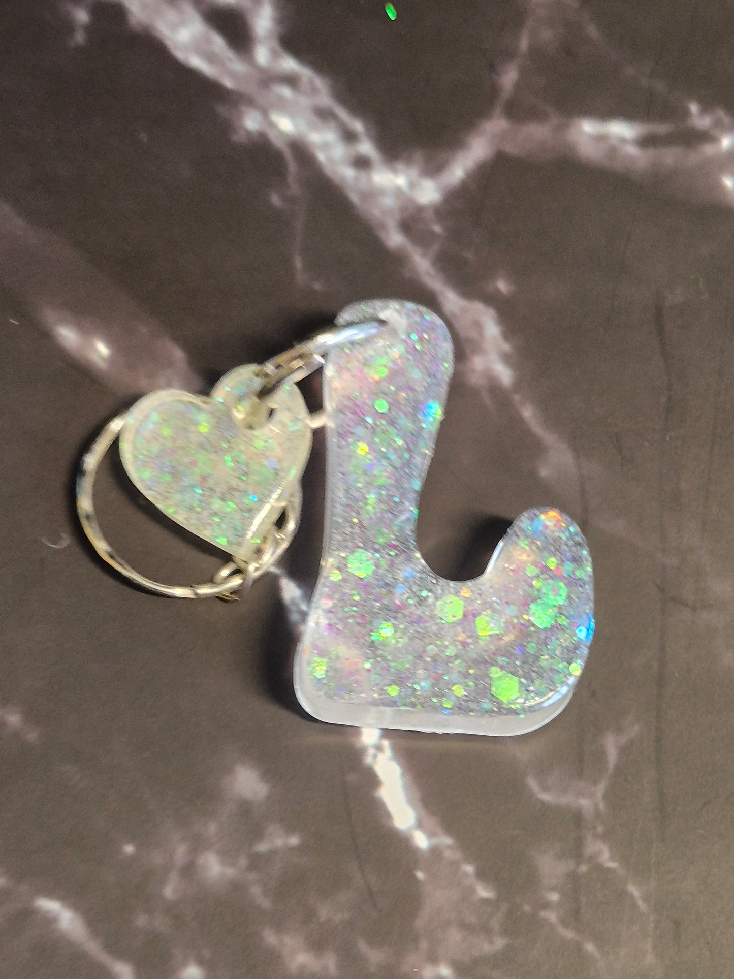 Llavero letra L de resina epoxi plateada con glitter y colgante de corazón