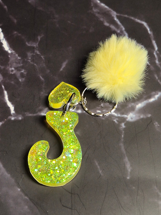 Llavero letra J de resina epoxi verde lima con glitter y pompón amarillo
