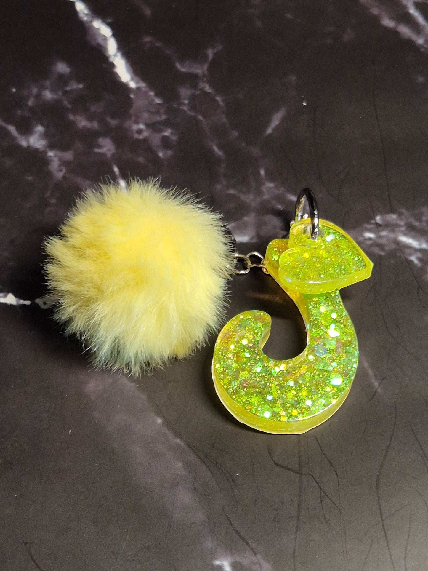 Llavero letra J de resina epoxi verde lima con glitter y pompón amarillo