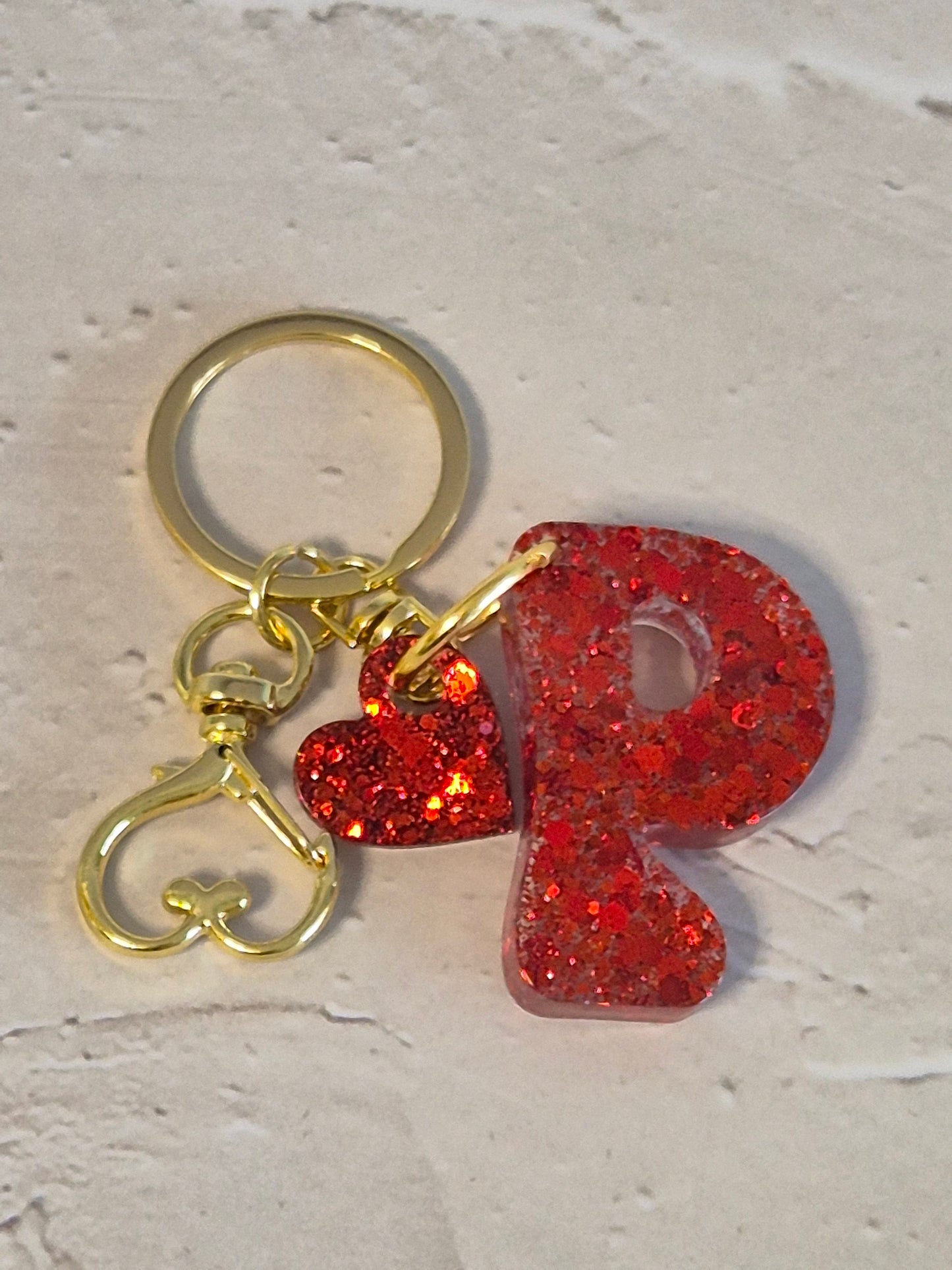 Llavero letra P de resina epoxi roja con glitter y anilla dorada