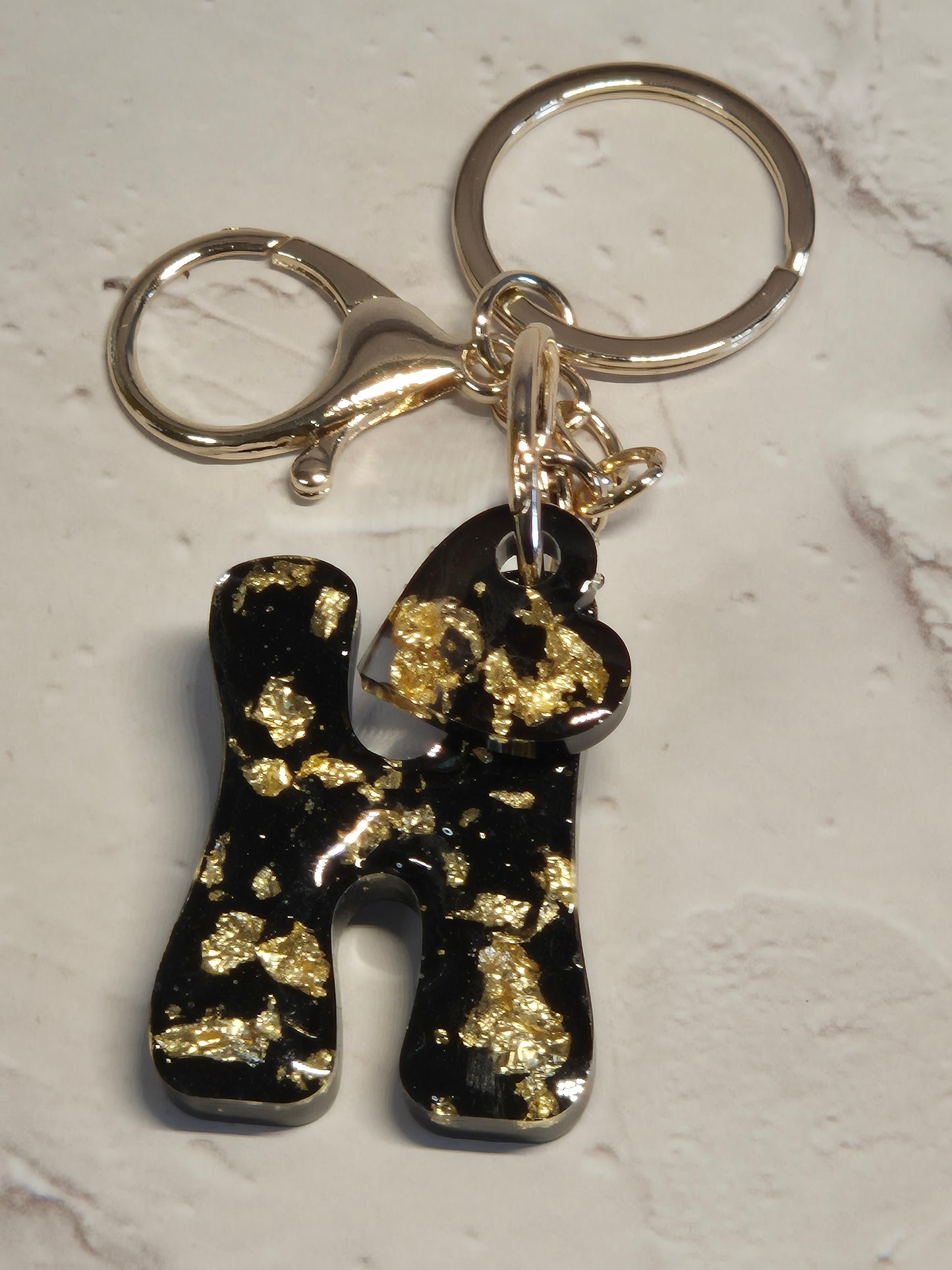 Llavero letra H de resina epoxi negra con pan de oro, corazón y herrajes dorados